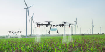 Agriculture drone fly to spray fertilizer on the sugarcane fields, Smart farm 4.0 concept