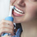 Close up of brushing teeth with electric toothbrush. Young woman